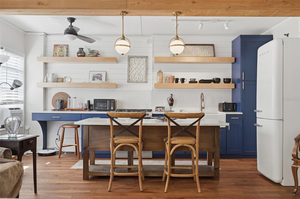 A kitchen features a white farmhouse sink, a wooden island, and open shelving — 130 4TH AVENUE N UNIT 504, ST PETERSBURG, FL