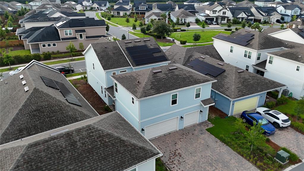 An aerial view shows several suburban houses with solar panels on their shingled roofs — 6518 WINDING PATH WAY, ST CLOUD, FL