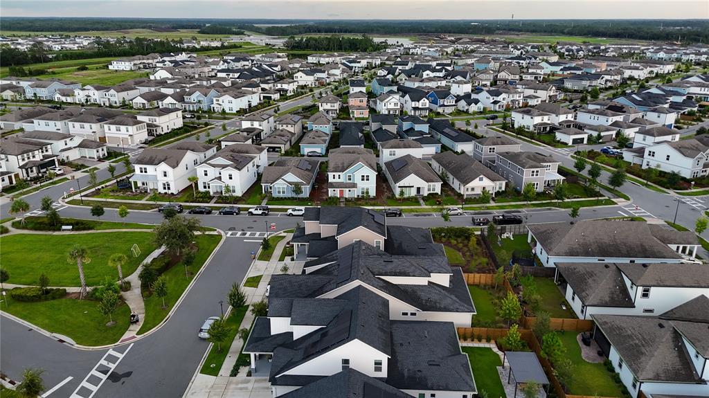 An aerial view shows a suburban neighborhood with numerous single-family homes and paved streets — 6518 WINDING PATH WAY, ST CLOUD, FL