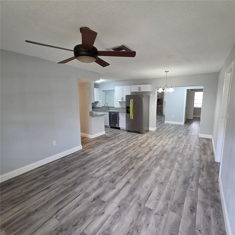 A room with light wood-look flooring, a stainless steel refrigerator, and a ceiling fan — 810 SWISS LANE, ORLANDO, FL