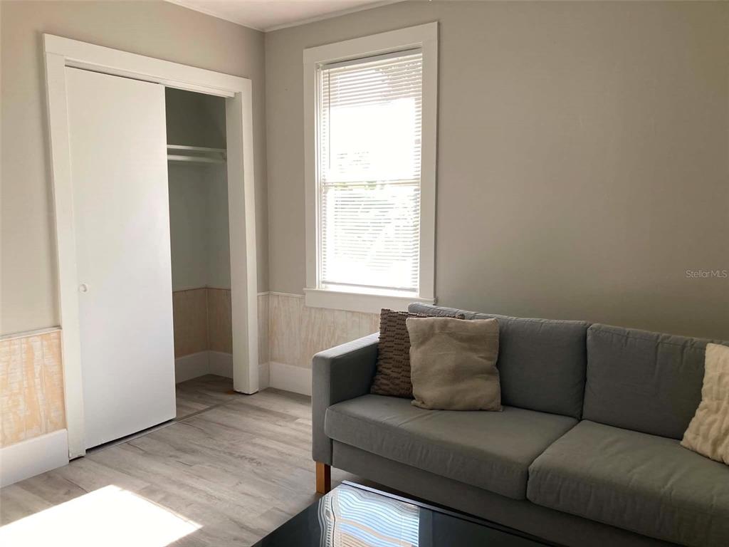 A kitchen with white cabinets, a glass-top dining table, and light wood-look flooring — 31 W OAKWOOD STREET UNIT 2, TARPON SPRINGS, FL