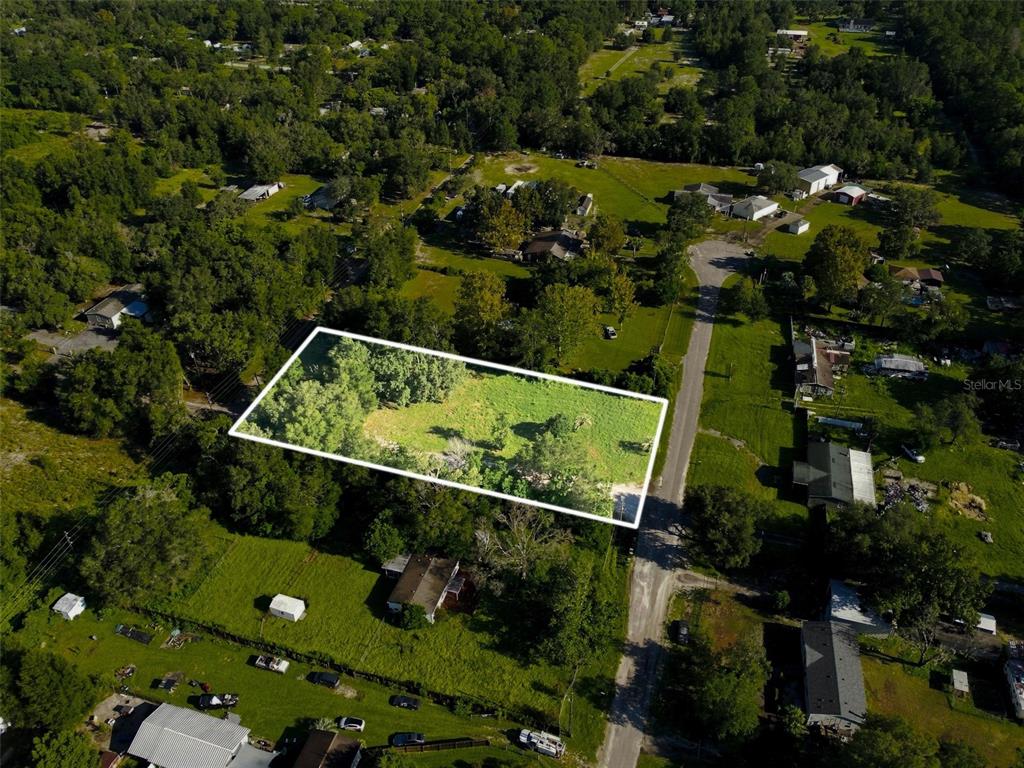An aerial view shows a rectangular vacant lot outlined in white next to a road — 18019 GOOD HOPE LANE, SPRING HILL, FL