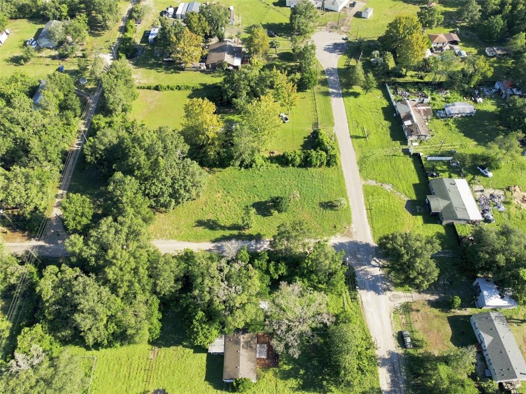 An aerial view shows a vacant grassy lot surrounded by trees and residential houses — 18019 GOOD HOPE LANE, SPRING HILL, FL