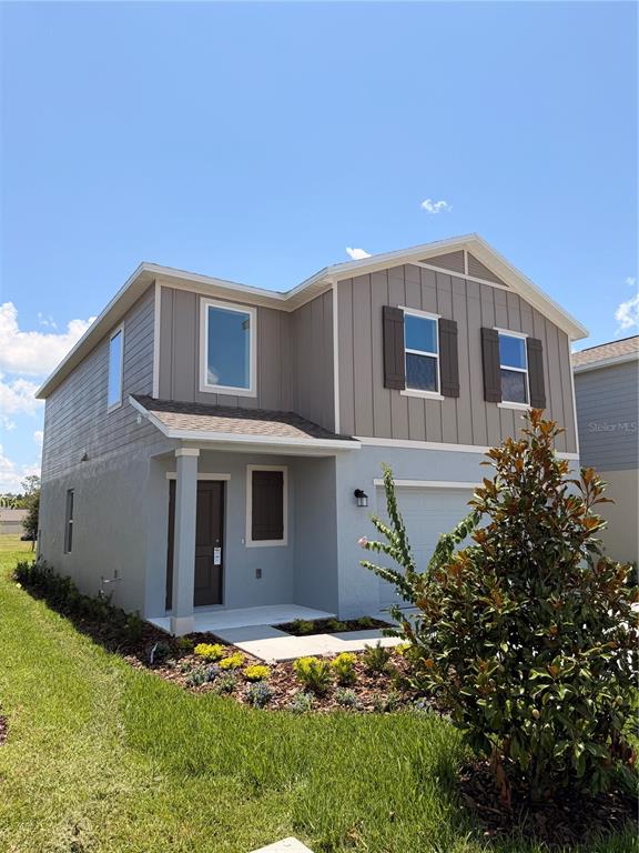 A two-story house features gray siding, a covered entryway, and a small front yard — 2470 HALLOW GARDEN RD, EUSTIS, FL