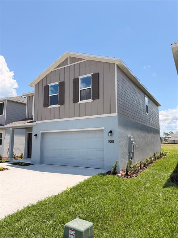 A two-story house features a light blue stucco lower level and gray vertical siding above — 2470 HALLOW GARDEN RD, EUSTIS, FL