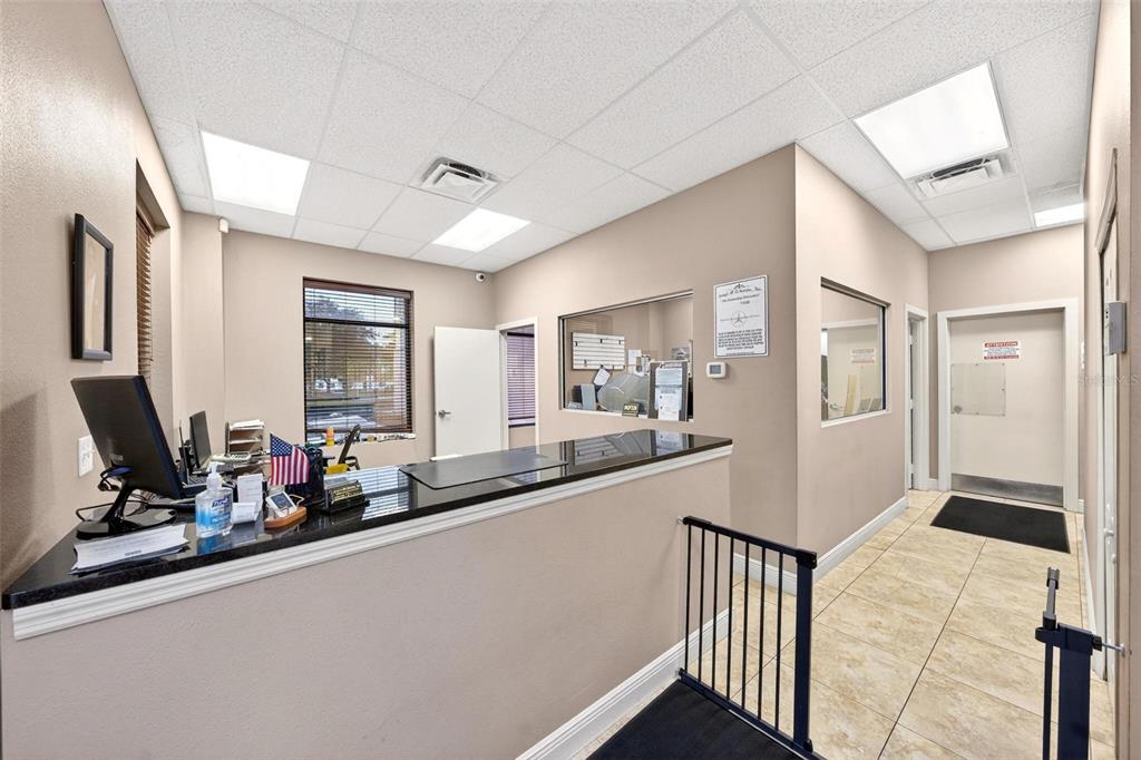 A reception area features a black granite counter, tile flooring, and a drop ceiling — 551 S ECON CIRCLE, OVIEDO, FL