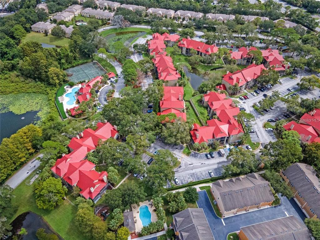 An aerial view shows a residential apartment complex with red roofs, swimming pools, and parking — 199 AFTON SQUARE UNIT 308, ALTAMONTE SPRINGS, FL