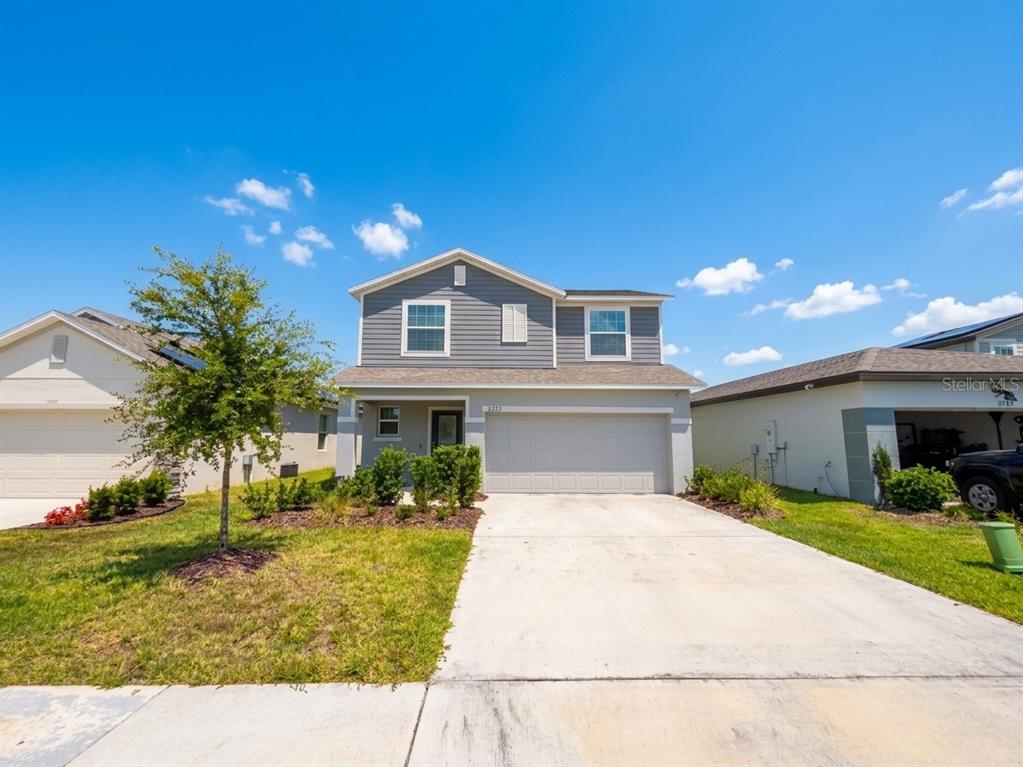 A two-story house with gray siding, a two-car garage, and a concrete driveway — 2727 SAN MARCO WAY, WINTER HAVEN, FL