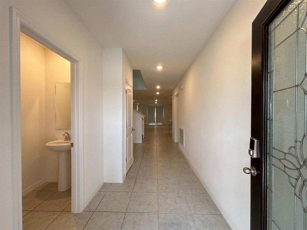 A tiled entryway leads to a hallway with a half bathroom on the left — 2727 SAN MARCO WAY, WINTER HAVEN, FL