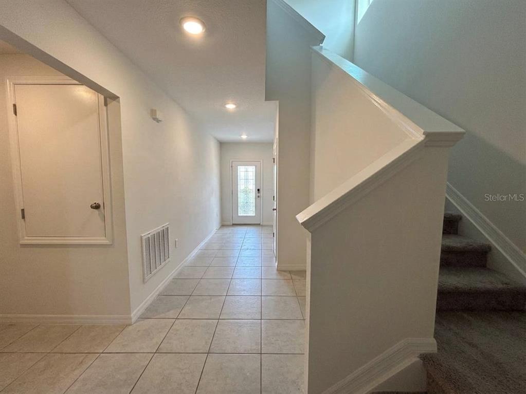 A tiled entryway leads to a front door with stairs on the right — 2727 SAN MARCO WAY, WINTER HAVEN, FL