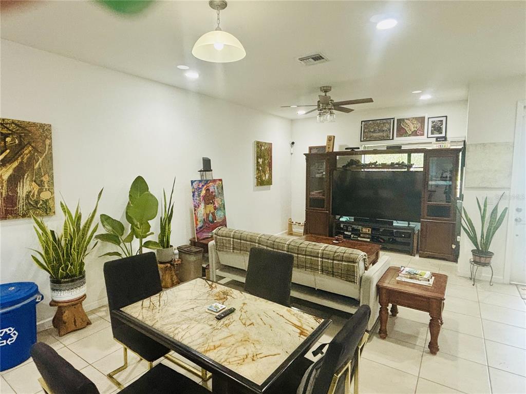 A living room and dining area feature tile flooring, a marble-topped table, and a large entertainment center — 2132 NW 6TH STREET, FORT LAUDERDALE, FL