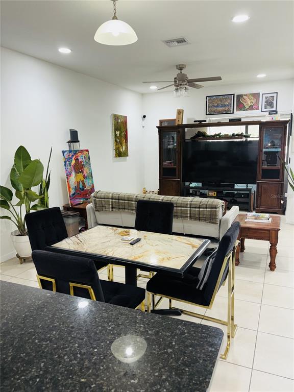 A dining area with a marble-topped table and black chairs sits before a living room — 2132 NW 6TH STREET, FORT LAUDERDALE, FL