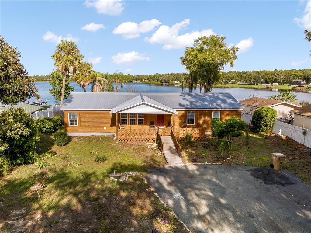 An elevated view of a wood-sided house with a metal roof and a lakefront backyard — 36112 LAKE UNITY ROAD, FRUITLAND PARK, FL
