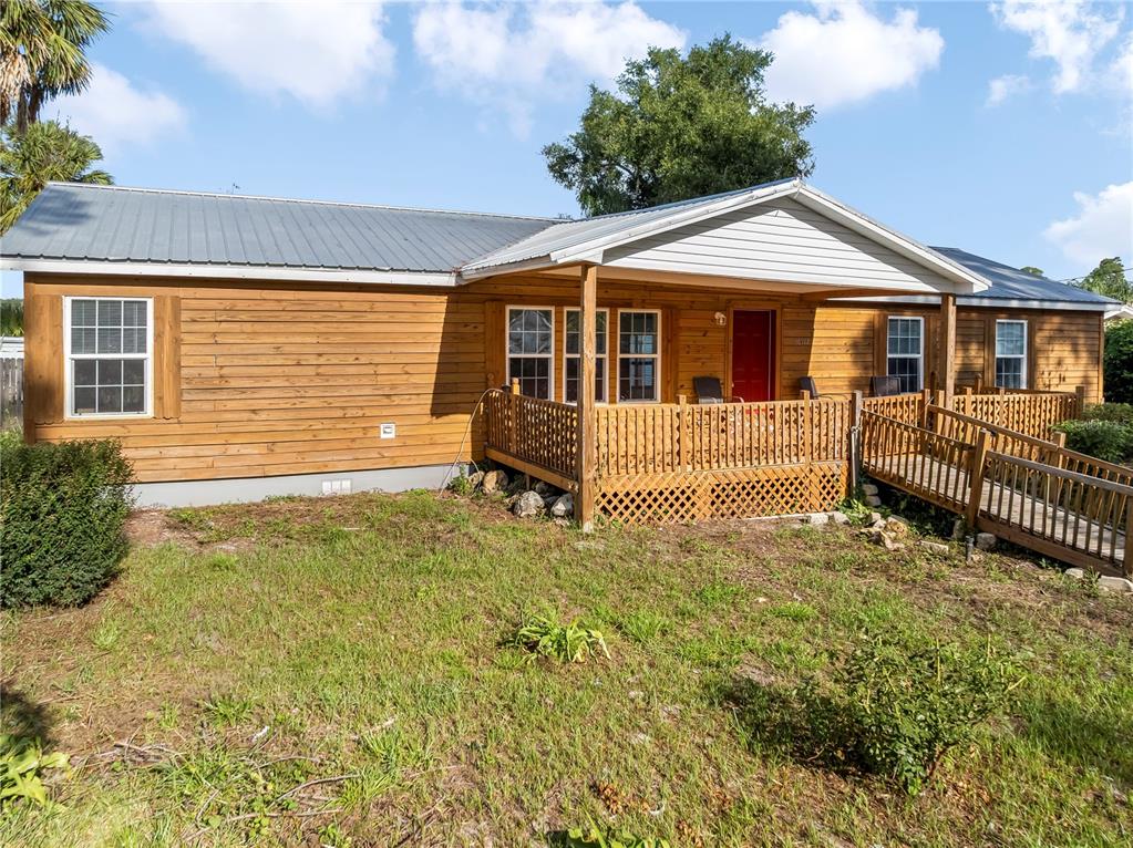 A single-story home with wood siding, a metal roof, and a wooden porch with ramp — 36112 LAKE UNITY ROAD, FRUITLAND PARK, FL