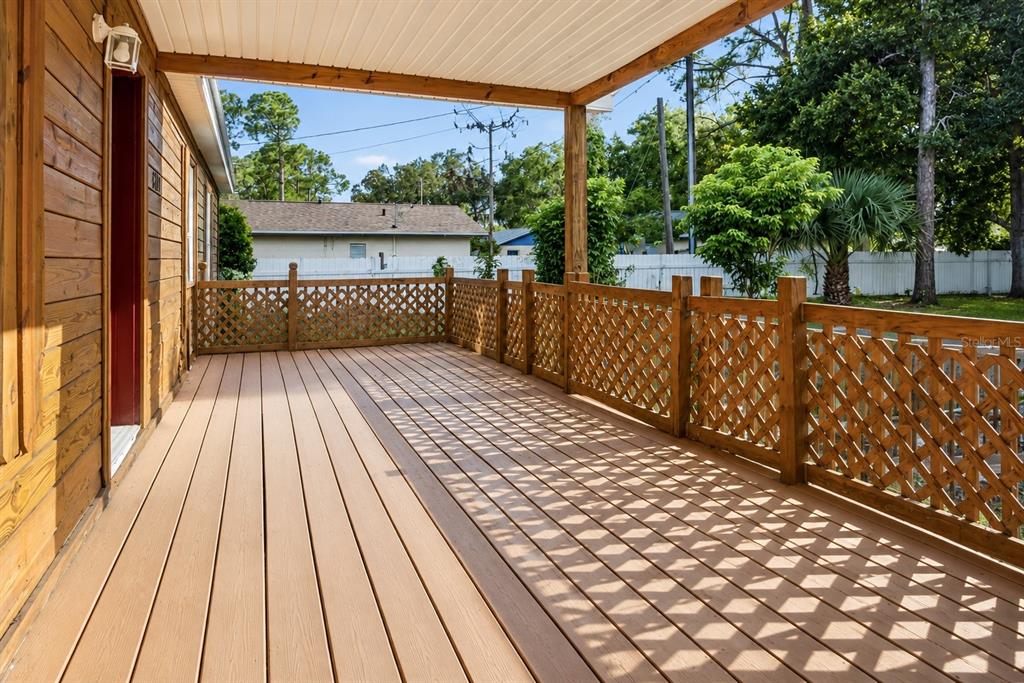 A wooden deck with lattice railings and a covered porch area attached to a house — 36112 LAKE UNITY ROAD, FRUITLAND PARK, FL