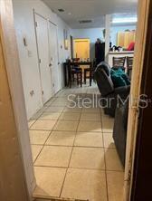 A view from a doorway looking into a tiled room with a dining set and recliner — 1603 ROSE LANE, EUSTIS, FL