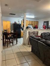 A kitchen with wooden cabinets and a dining area with a table and chairs — 1603 ROSE LANE, EUSTIS, FL