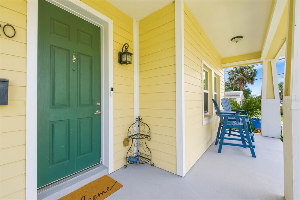 A two-story yellow house with a front porch, concrete walkway, and landscaped lawn — 4920 3RD STREET N, ST PETERSBURG, FL