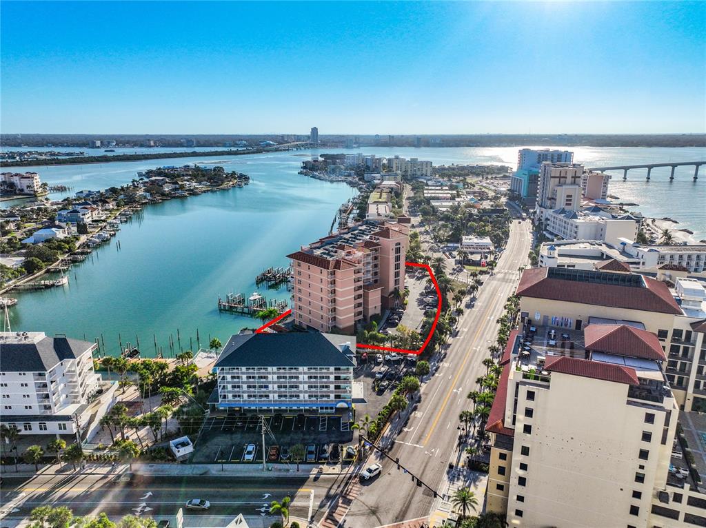 An aerial view shows a multi-story waterfront building complex with a parking lot and docks — 530 S GULFVIEW BOULEVARD UNIT 500, CLEARWATER, FL