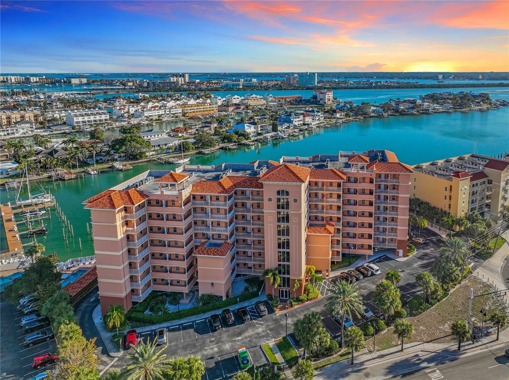 An aerial view of a multi-story apartment building with a tiled roof near the water — 530 S GULFVIEW BOULEVARD UNIT 500, CLEARWATER, FL