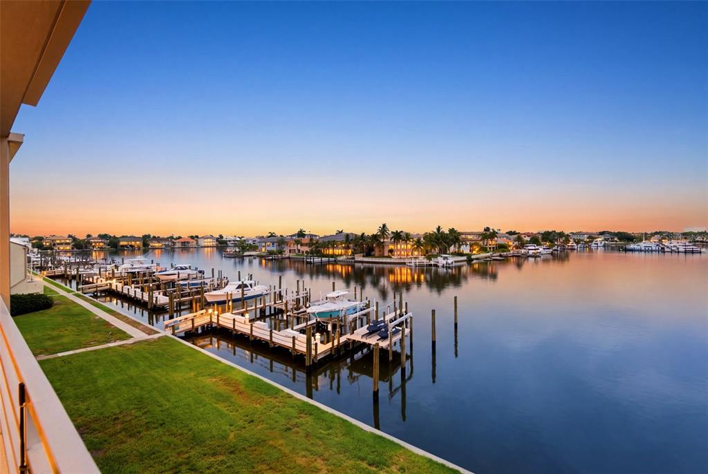 A view of a canal with boat docks and houses at sunset from a balcony — 2775 KIPPS COLONY DRIVE S UNIT 305, GULFPORT, FL
