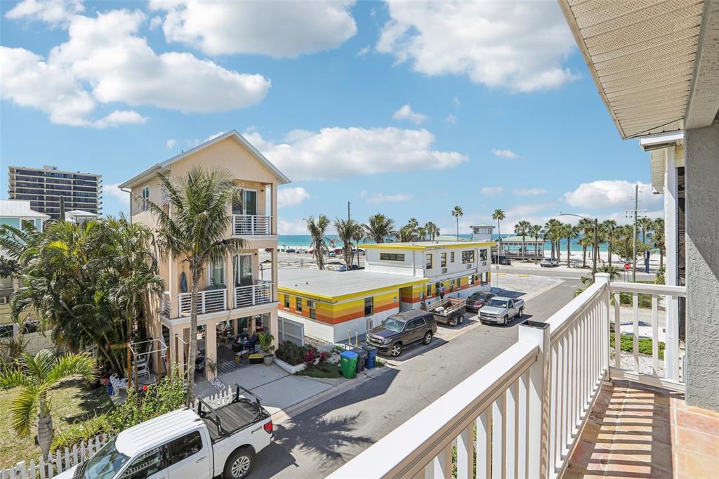 An aerial view shows a coastal town with high-rise buildings, residential homes, and a sandy beach — 23 80TH AVENUE, TREASURE ISLAND, FL