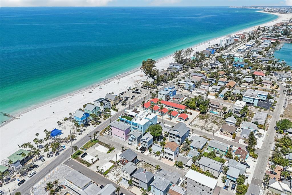 An elevated view from a balcony overlooking a street, beach houses, and the ocean — 23 80TH AVENUE, TREASURE ISLAND, FL