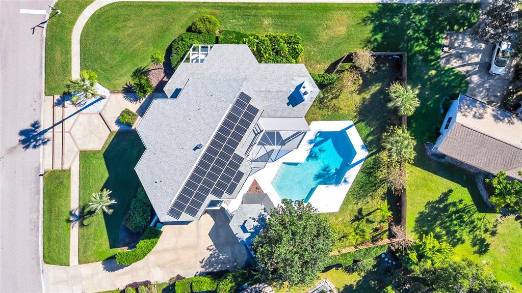 An aerial view of a house with solar panels, a swimming pool, and a driveway — 8922 BAY COVE COURT, ORLANDO, FL