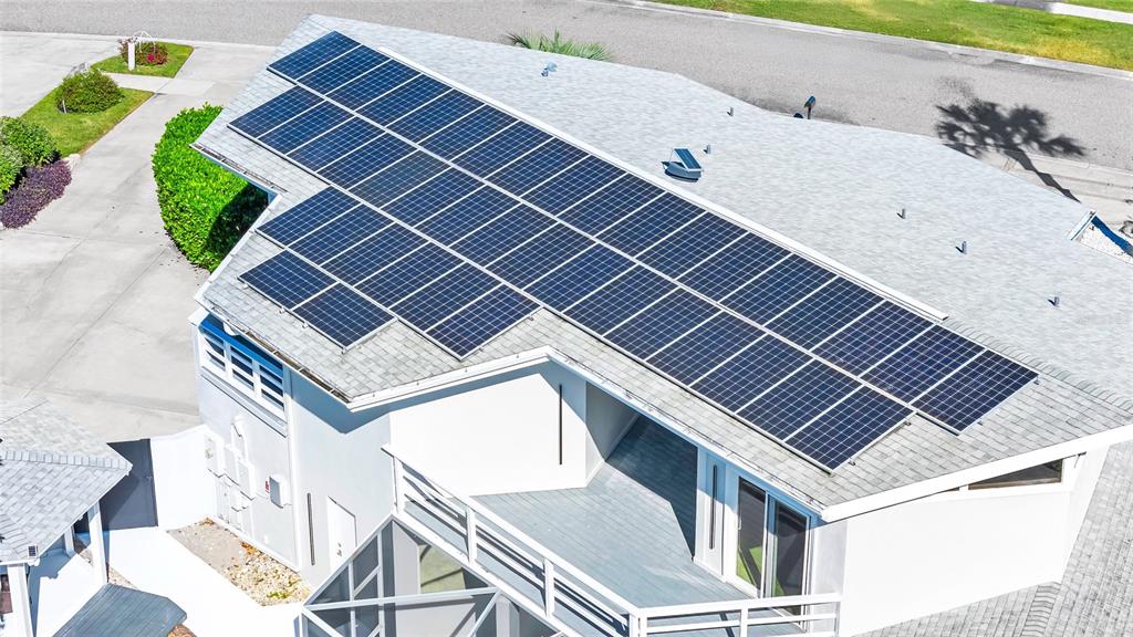 An aerial view shows a residential roof covered with a large array of solar panels — 8922 BAY COVE COURT, ORLANDO, FL