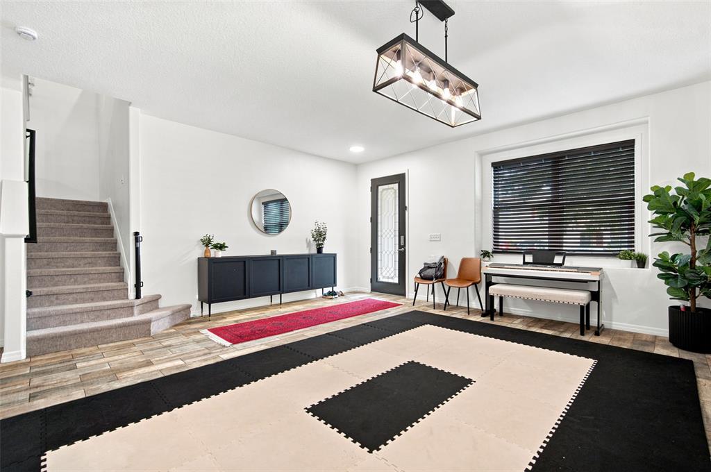 A bright entryway features a staircase, a black console table, and a large floor mat — 428 CHIMNEY ROCK DRIVE, RUSKIN, FL