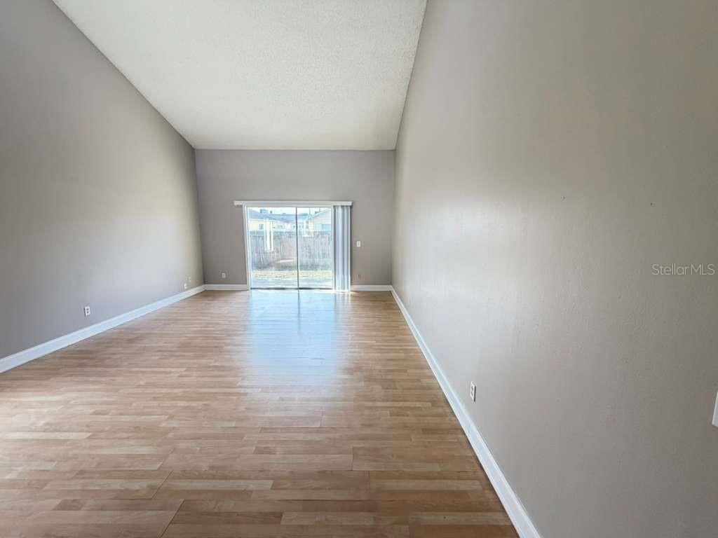 A hallway with light wood-look flooring, gray walls, and several white interior doors — 118 DAHLIA VILLAGE CIRCLE UNIT 79, ORLANDO, FL