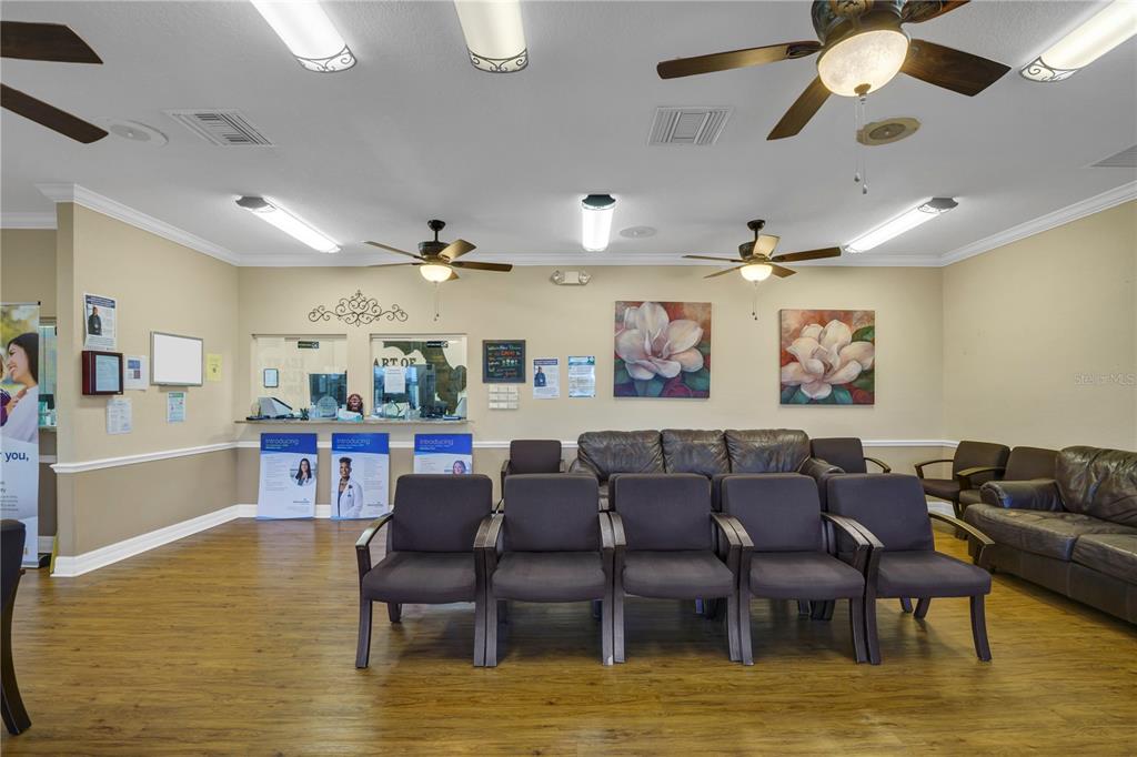 A waiting room features rows of chairs, leather sofas, floral wall art, and wood flooring — 2221 NORTH BOULEVARD W, DAVENPORT, FL