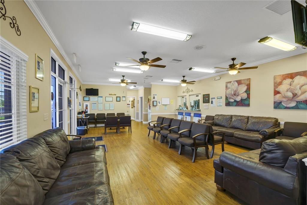 A waiting room features brown leather sofas, rows of chairs, and wood-look flooring — 2221 NORTH BOULEVARD W, DAVENPORT, FL