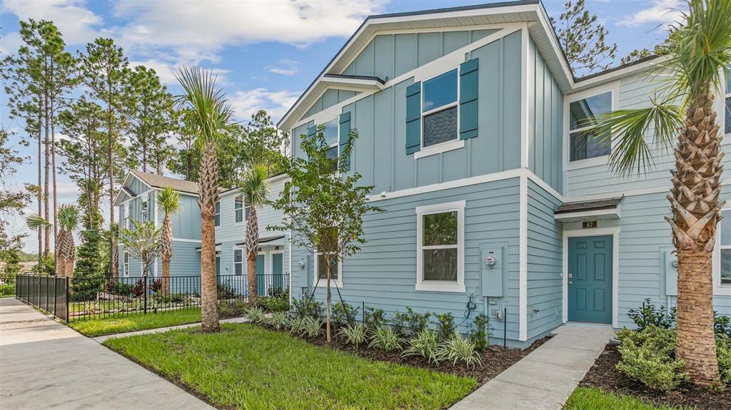 A two-story light blue townhouse with a teal front door and palm trees in front — 289 AYAMONTE ROAD, ST AUGUSTINE, FL