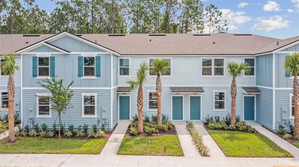 A row of light blue two-story townhomes with teal doors and small front palm trees — 289 AYAMONTE ROAD, ST AUGUSTINE, FL