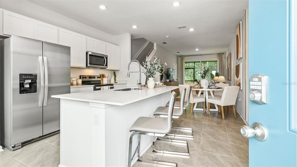 A modern kitchen features white cabinets, stainless steel appliances, and a central island with seating — 289 AYAMONTE ROAD, ST AUGUSTINE, FL