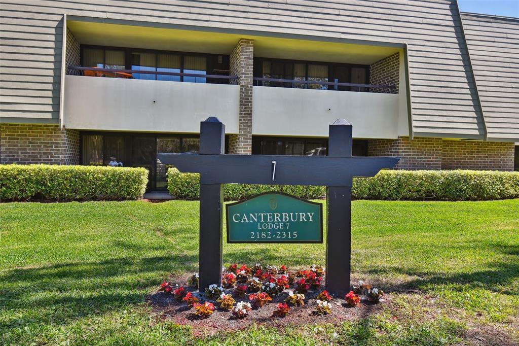 A covered patio overlooks a grassy lawn, a lake, and trees on a sunny day — 36750 US HIGHWAY 19 N UNIT 04138, PALM HARBOR, FL