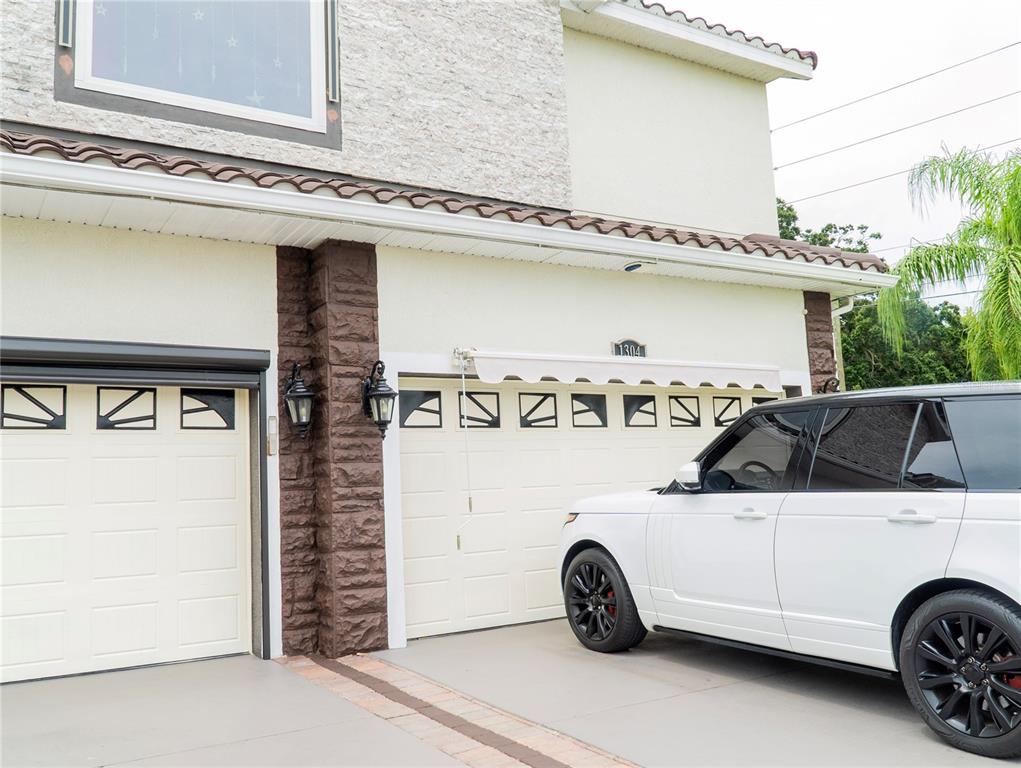 A white SUV is parked in the driveway in front of a two-car garage — 1304 OCOEE APOPKA ROAD, OCOEE, FL