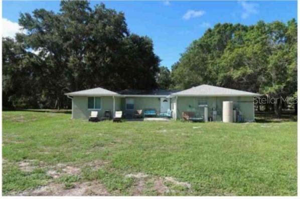 A light green, single-story house with a hip roof sits on a large, grassy lot — 751 ARABIAN CIRCLE, NOKOMIS, FL