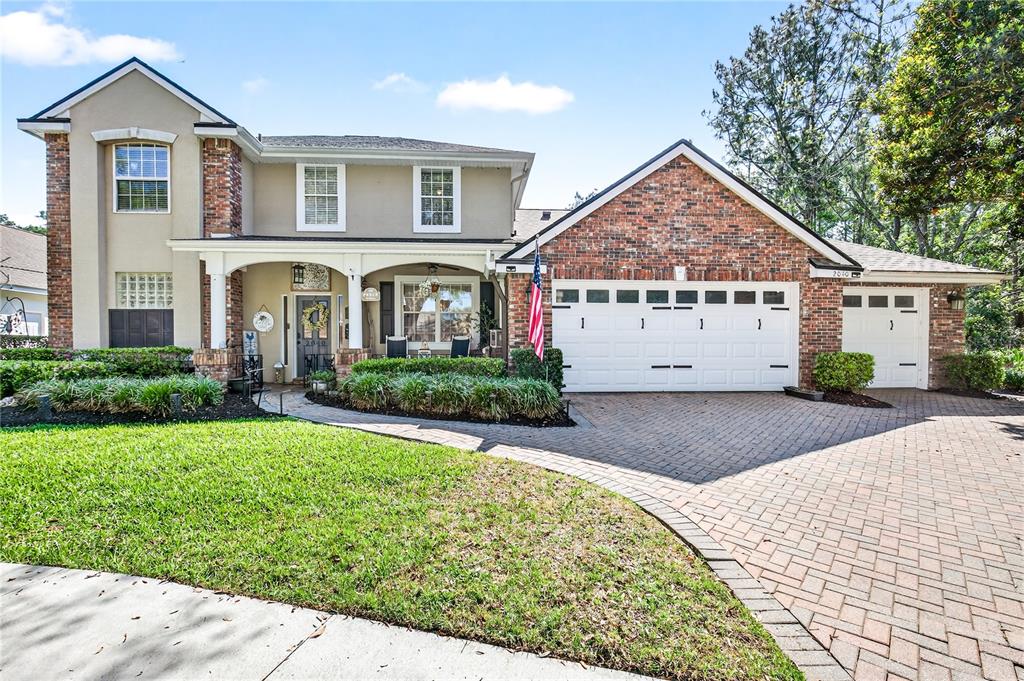 A two-story house with a brick and stucco facade, a paved driveway, and a front porch — 2040 PARK FOREST BOULEVARD, MOUNT DORA, FL