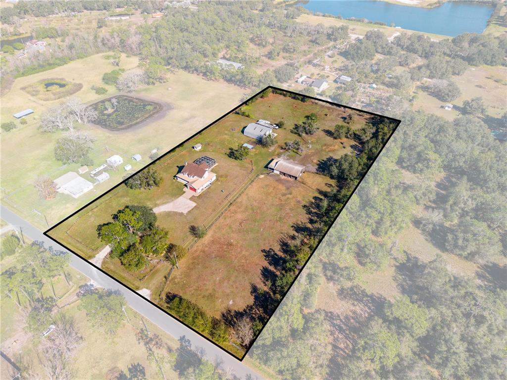 An aerial view shows a house, outbuildings, and fenced acreage on a rural lot — 3255 TUCKER AVENUE, ST CLOUD, FL