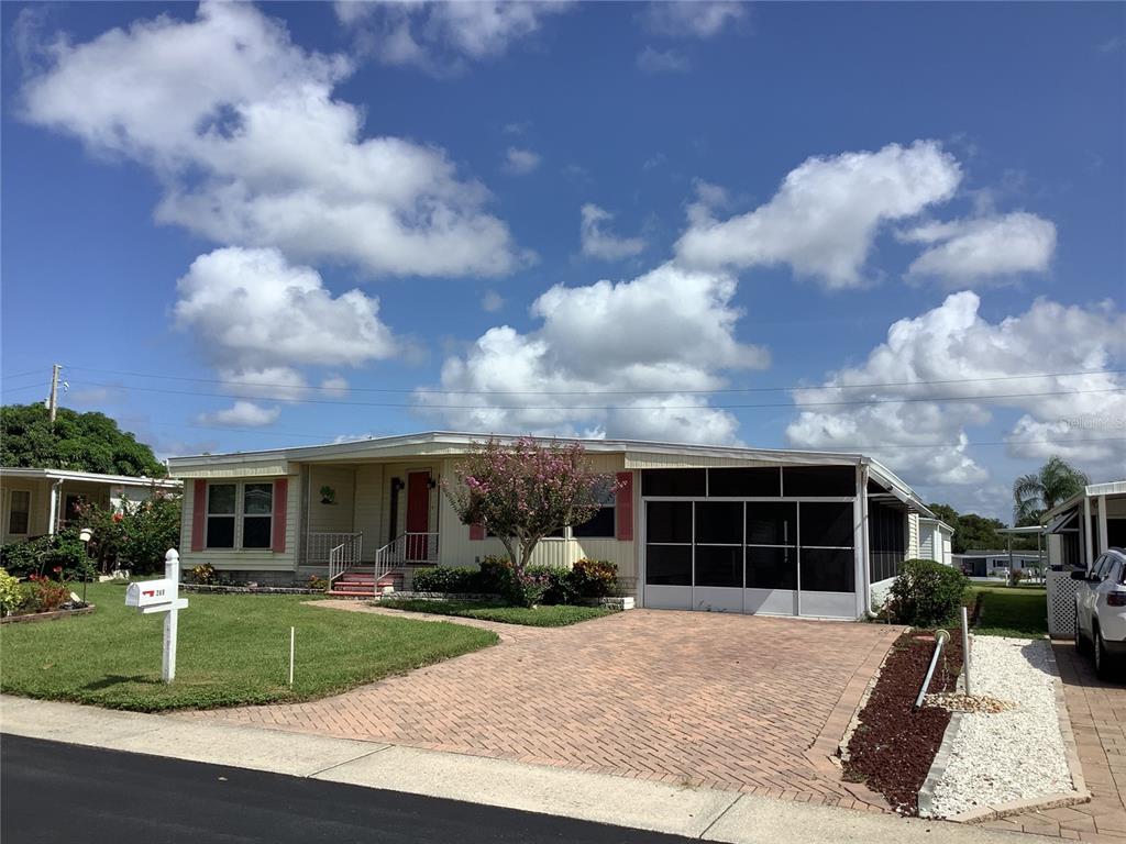 A single-story manufactured home with a brick paver driveway and a screened-in front porch — 269 SALEM AVENUE UNIT 9, PALM HARBOR, FL