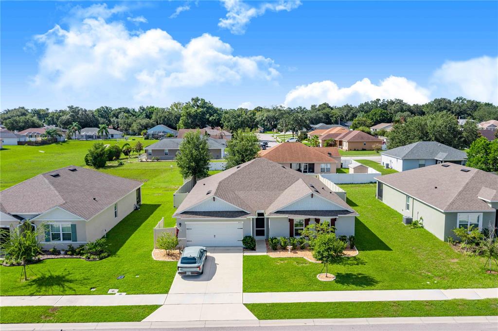 An aerial view shows a single-story suburban house with a gray roof and driveway — 803 AUBURN GROVE COURT, AUBURNDALE, FL