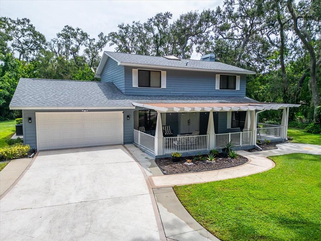 A two-story blue house with a garage, a front porch, and a concrete driveway — 6512 93RD STREET E, BRADENTON, FL