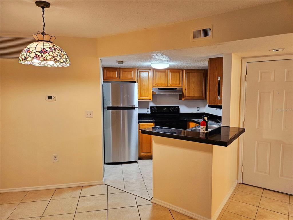 An exterior view shows a beige door and a sliding glass door on a patio — 1916 LAKE ATRIUMS CIRCLE UNIT 25, ORLANDO, FL