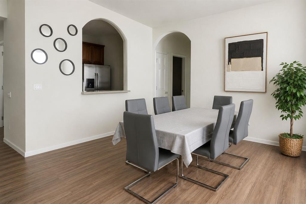 A dining room features gray chairs, a table with a tablecloth, and wall-mounted circular mirrors — 3338 ROBERT TRENT JONES DRIVE UNIT 410, ORLANDO, FL