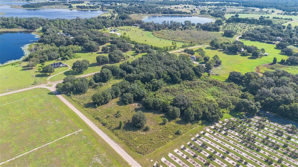 An aerial view shows a rural landscape with a road, trees, fields, and two lakes — YALE HAMMOCK ROAD, UMATILLA, FL