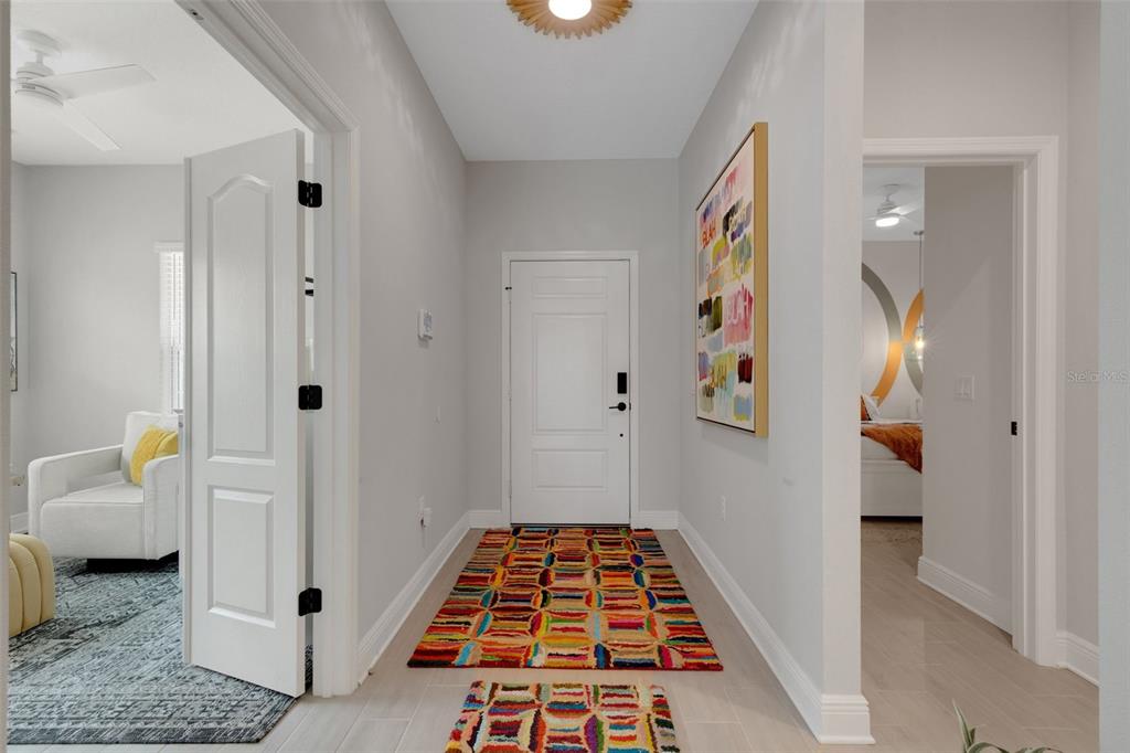 A bright entryway features a colorful rug, a white front door, and light tile flooring — 4661 WILLOW BEND AVENUE, PARRISH, FL