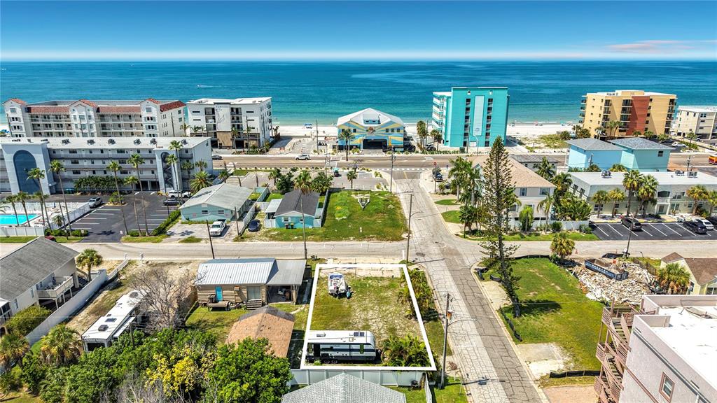An aerial view shows a vacant rectangular lot with a trailer and boat near the beach — 14065 PALM ST, MADEIRA BEACH, FL
