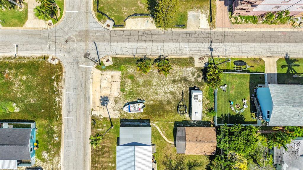 An aerial view shows a vacant lot with a boat, trailer, and small shed — 14065 PALM ST, MADEIRA BEACH, FL